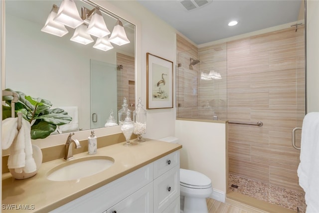 bathroom featuring vanity, toilet, and an enclosed shower