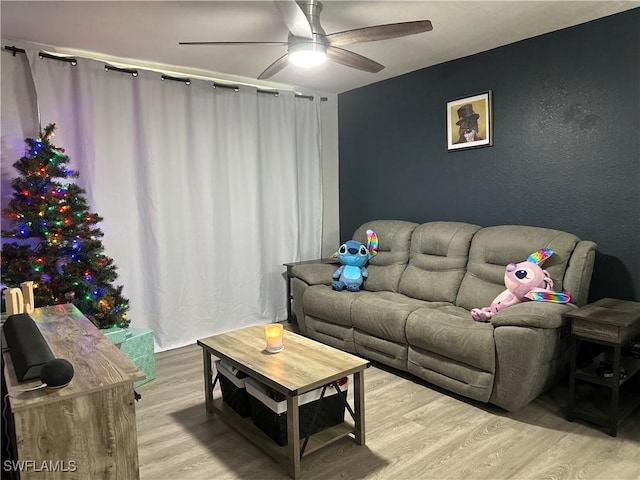 living room featuring ceiling fan and light wood-type flooring