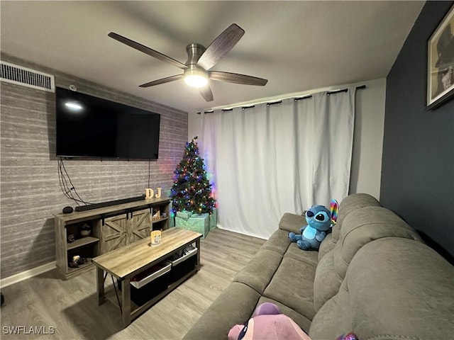 living room featuring wood-type flooring and ceiling fan