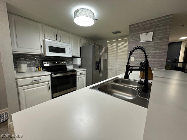 kitchen with white cabinets, decorative backsplash, sink, and appliances with stainless steel finishes