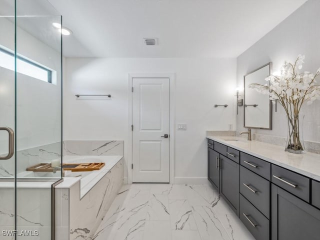 bathroom featuring vanity and a relaxing tiled tub