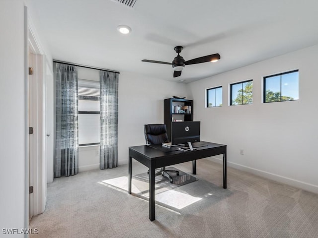 carpeted home office featuring ceiling fan