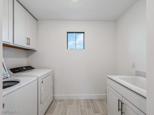 laundry room with cabinets, washing machine and dryer, and sink