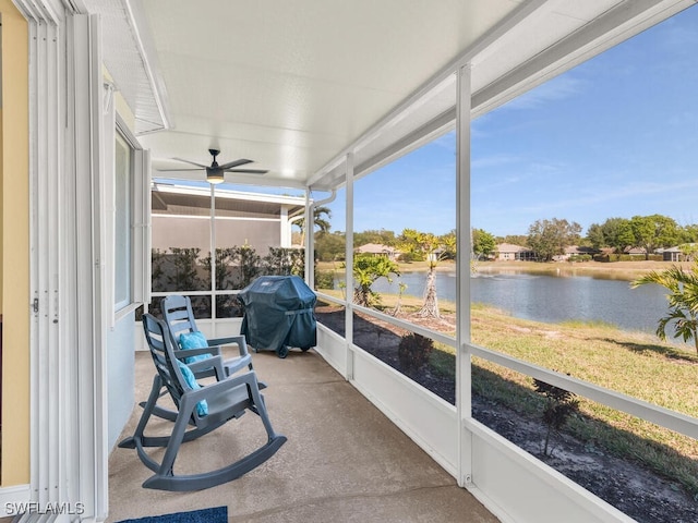 sunroom / solarium with ceiling fan and a water view