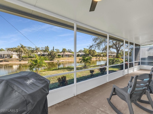 sunroom / solarium with ceiling fan and a water view