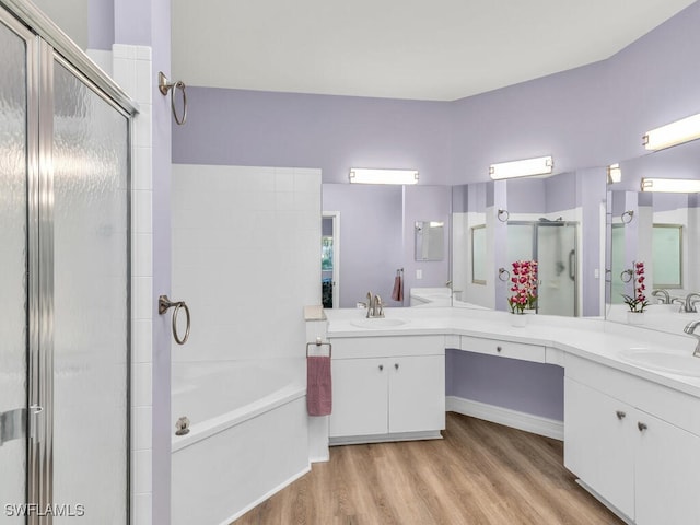 full bathroom with a garden tub, a stall shower, wood finished floors, and vanity