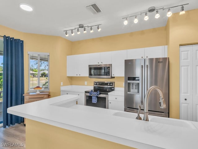 kitchen featuring light wood finished floors, light countertops, visible vents, appliances with stainless steel finishes, and white cabinets