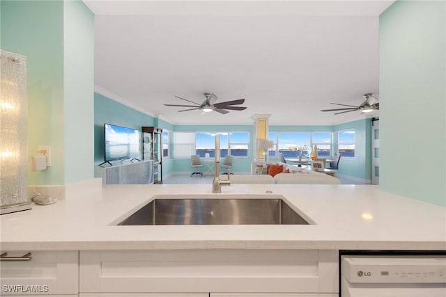 kitchen with white dishwasher, light stone counters, white cabinetry, and ornamental molding