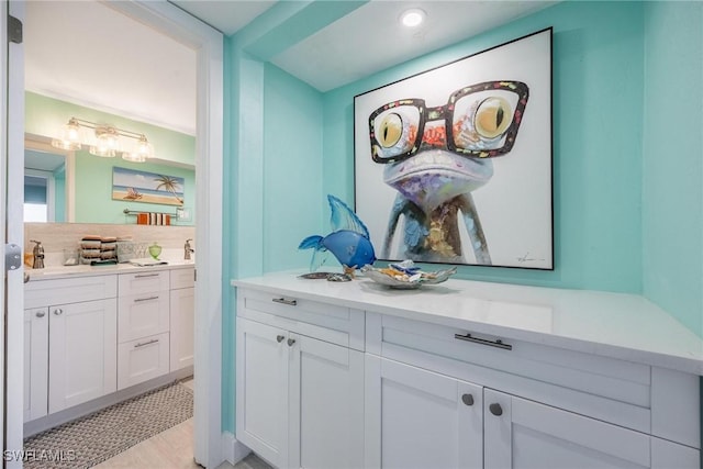 interior space featuring white cabinets, decorative backsplash, and light wood-type flooring