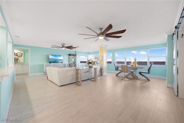 living room with ceiling fan and a barn door