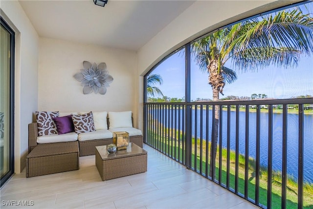 balcony featuring a water view and an outdoor living space