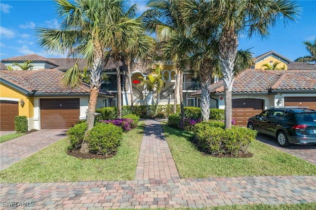 view of front of home with a garage, decorative driveway, a tile roof, and stucco siding