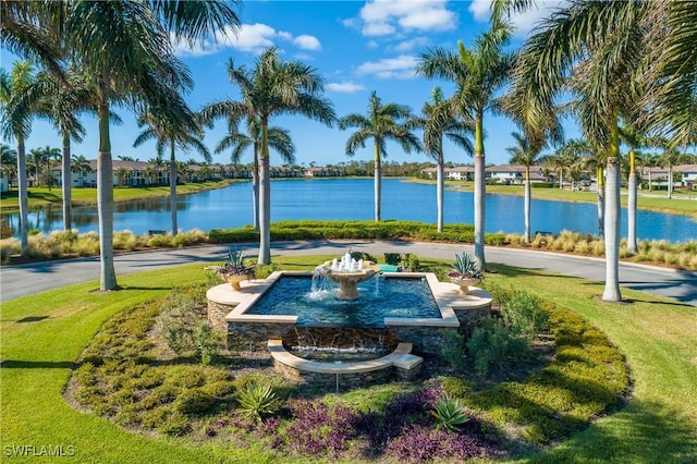 view of property's community featuring a lawn and a water view