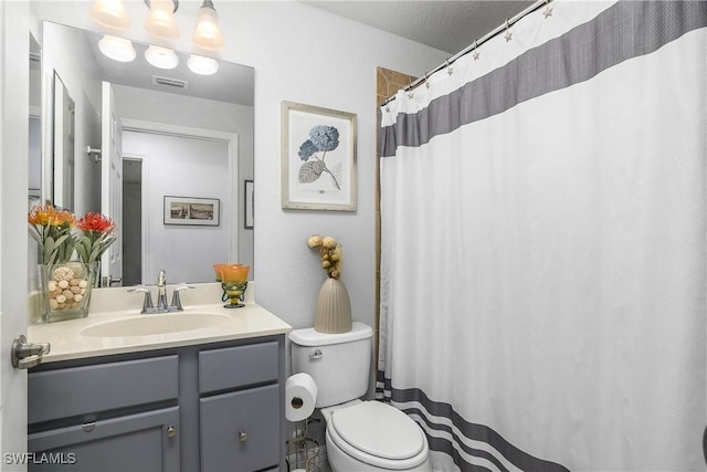 bathroom featuring visible vents, vanity, and toilet