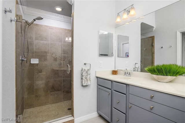 full bath with a stall shower, vanity, and baseboards