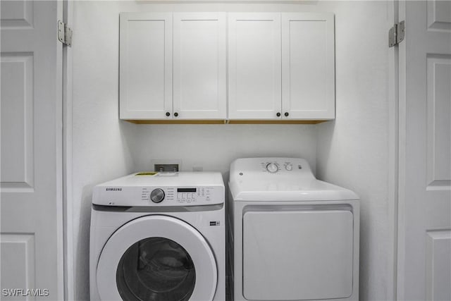 laundry room featuring cabinet space and washer and clothes dryer