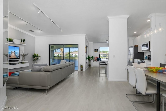 living area featuring ornamental molding, track lighting, visible vents, and light wood finished floors