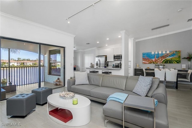 living area featuring visible vents, a water view, rail lighting, crown molding, and recessed lighting