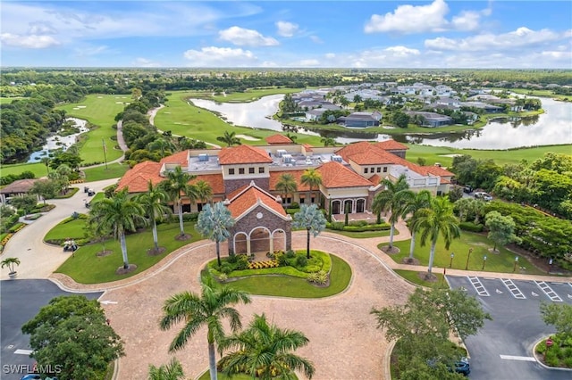 drone / aerial view with view of golf course and a water view