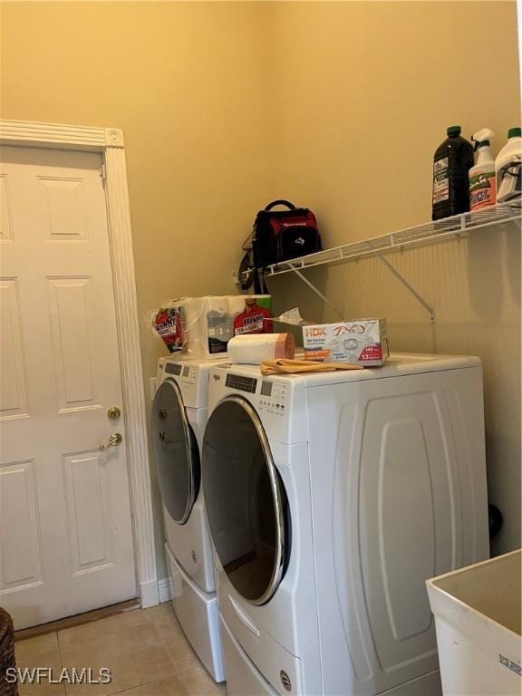 laundry area with washing machine and dryer, sink, and light tile patterned flooring