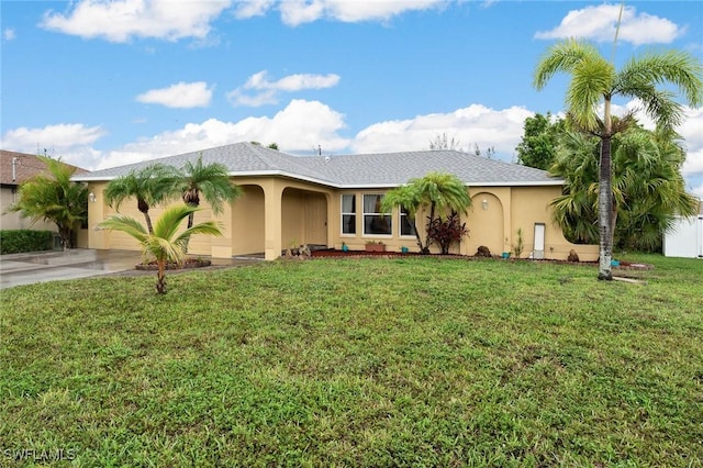 view of front of home featuring a front yard, driveway, an attached garage, and stucco siding