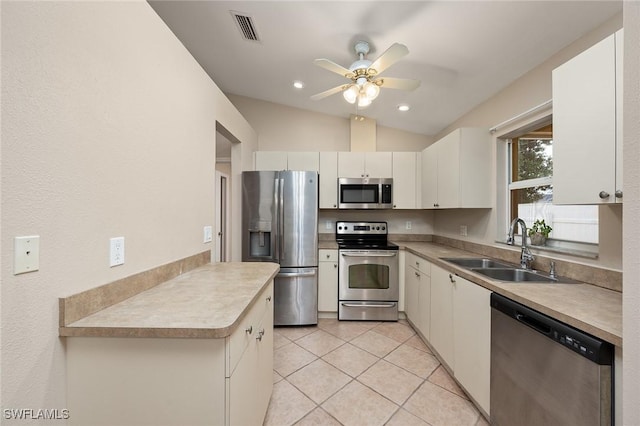 kitchen with sink, stainless steel appliances, white cabinets, lofted ceiling, and light tile patterned flooring