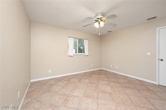 spare room with ceiling fan and light tile patterned floors