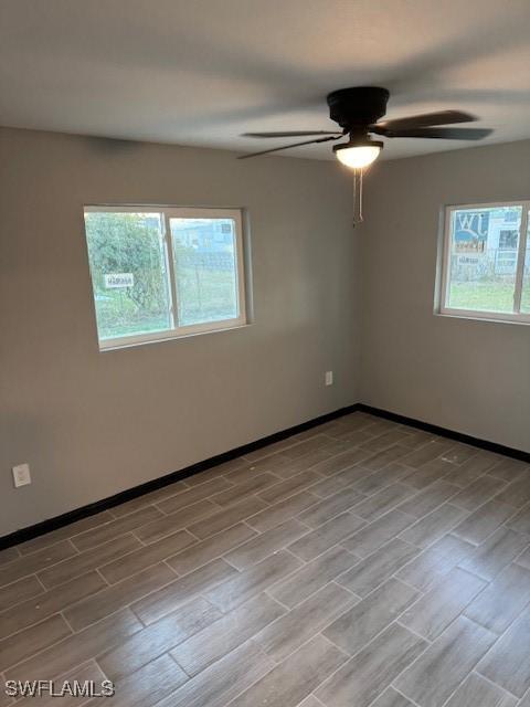 spare room featuring light hardwood / wood-style flooring, plenty of natural light, and ceiling fan