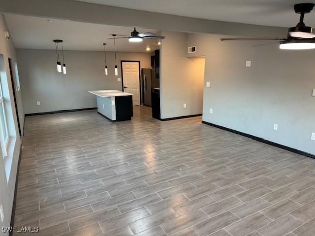 unfurnished living room with ceiling fan and light hardwood / wood-style flooring