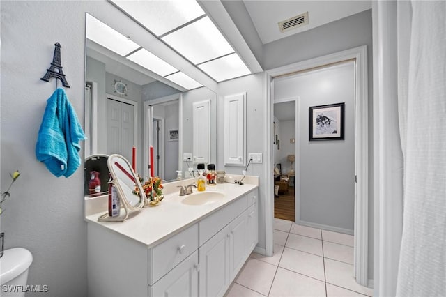 bathroom featuring tile patterned flooring, vanity, and toilet