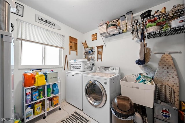 clothes washing area with washer and clothes dryer, light tile patterned flooring, and sink