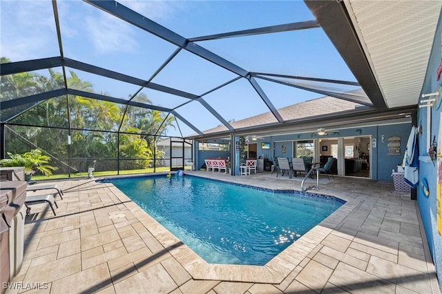 view of pool featuring a patio, glass enclosure, and ceiling fan