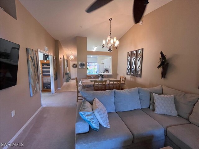 living room with lofted ceiling, light colored carpet, and an inviting chandelier