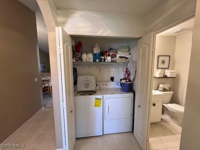 laundry room with light tile patterned floors and washing machine and dryer