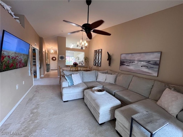 carpeted living room featuring ceiling fan with notable chandelier and vaulted ceiling