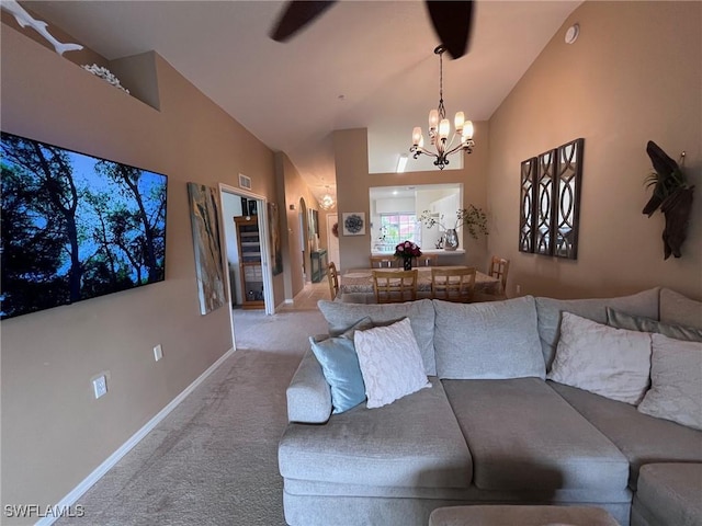 carpeted living room featuring a notable chandelier and vaulted ceiling