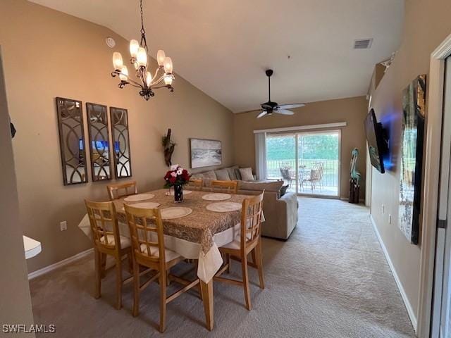 carpeted dining room featuring ceiling fan with notable chandelier and lofted ceiling