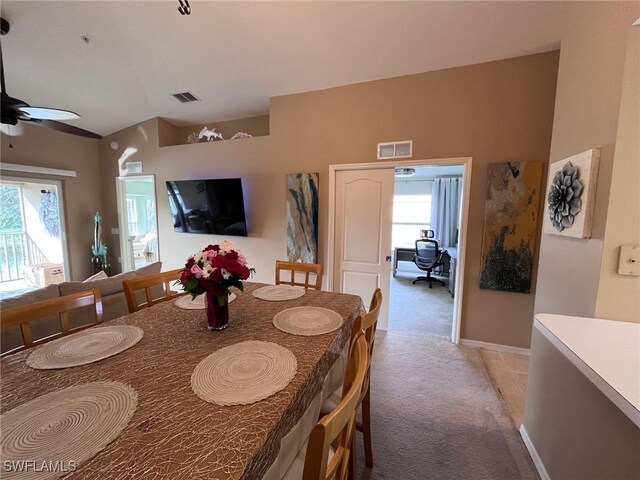 dining area with ceiling fan and light carpet