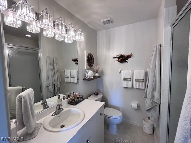 bathroom featuring a shower with shower door, toilet, a chandelier, tile patterned floors, and vanity