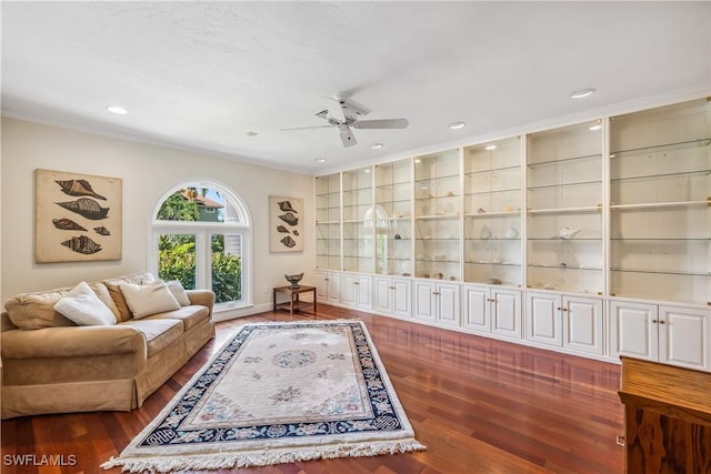 living room featuring built in features, ceiling fan, and dark wood-type flooring