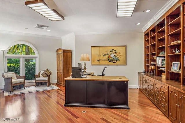 office with light hardwood / wood-style floors and ornamental molding