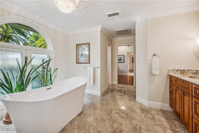 bathroom featuring a tub, vanity, a notable chandelier, and ornamental molding