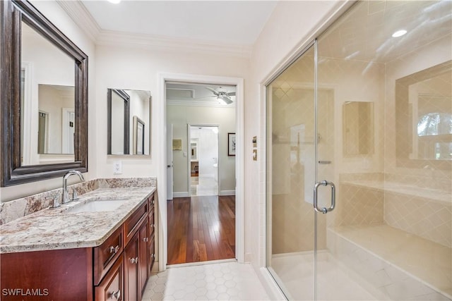 bathroom with walk in shower, vanity, ceiling fan, crown molding, and hardwood / wood-style floors