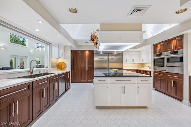 kitchen featuring decorative backsplash, sink, white cabinets, and appliances with stainless steel finishes