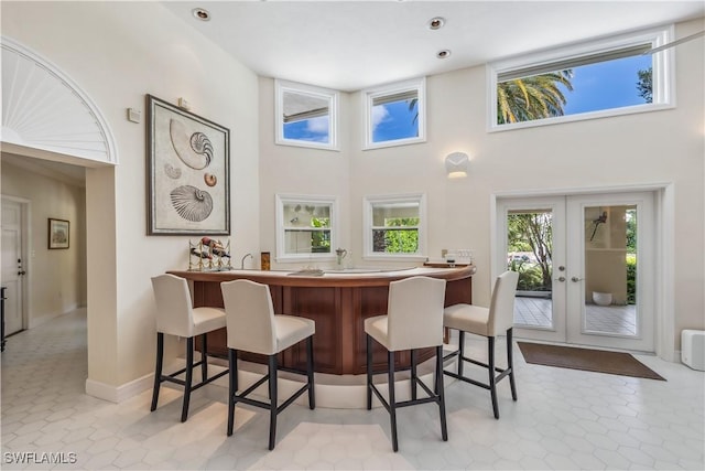 dining room with french doors and a towering ceiling