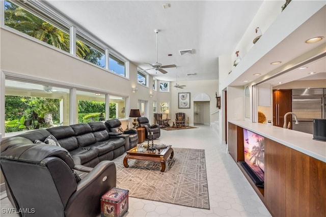 living room featuring a high ceiling and ceiling fan