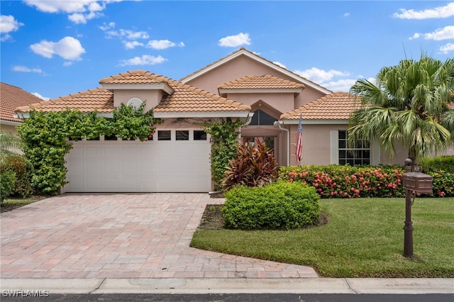 mediterranean / spanish-style house featuring a front yard and a garage