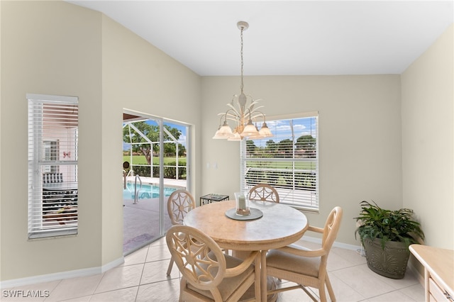 dining space featuring plenty of natural light, light tile patterned floors, vaulted ceiling, and an inviting chandelier