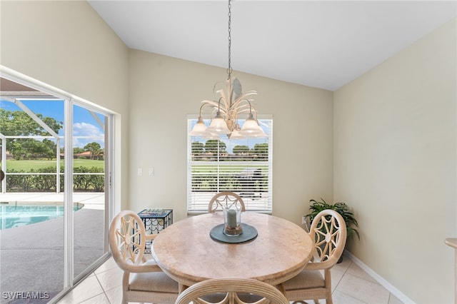 tiled dining space featuring a notable chandelier, a healthy amount of sunlight, and lofted ceiling