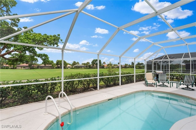 view of swimming pool featuring a lawn, glass enclosure, and a patio area